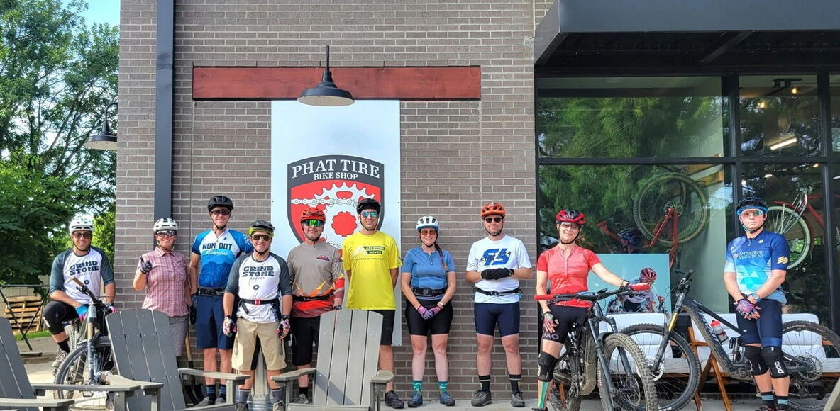 Grindstone riders posing with their bikes outside Phat Tire Bike Shop